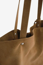 Isabelle Bag in Earth — strap and rivet close-up, on light grey