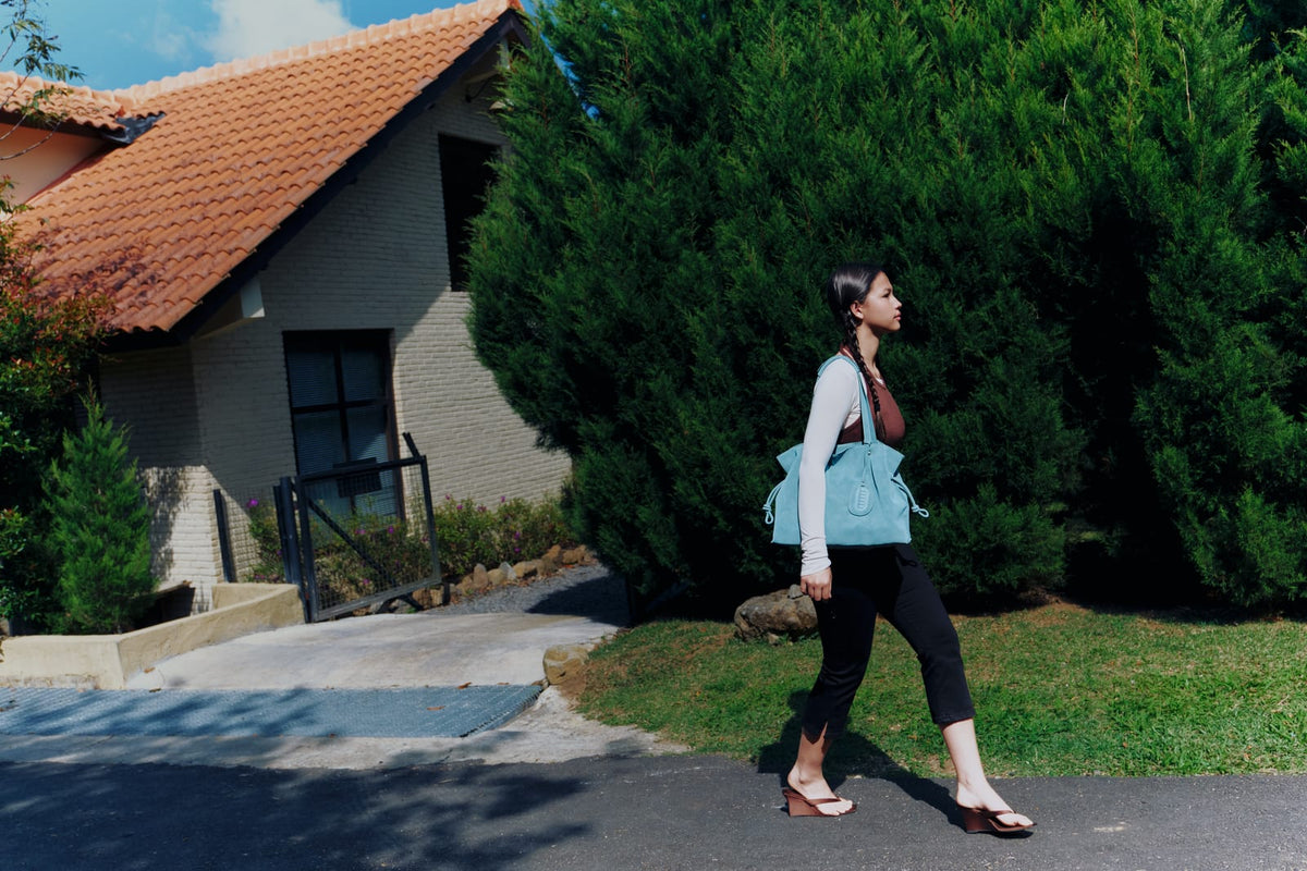 Isabelle Bag in Sky — campaign, walking past the houses