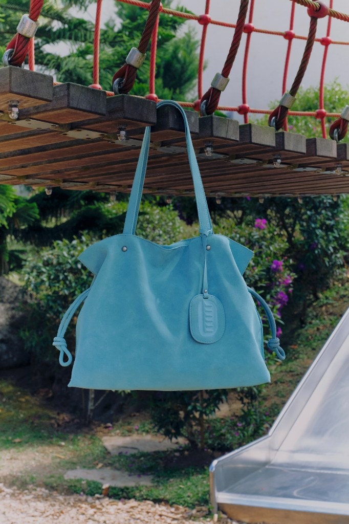 Isabelle Bag in Sky — hanging under a rope bridge